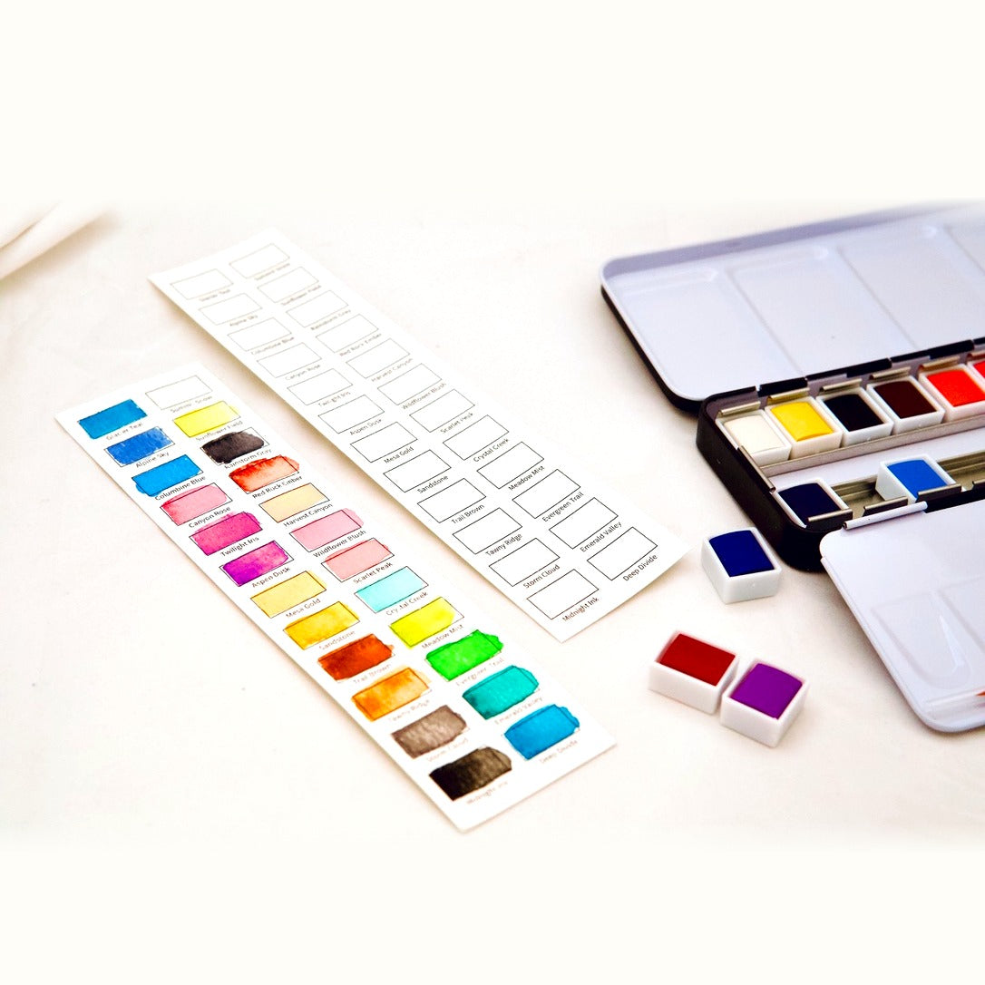 The Colorado 24 — swatch cards and open tin with watercolor pans