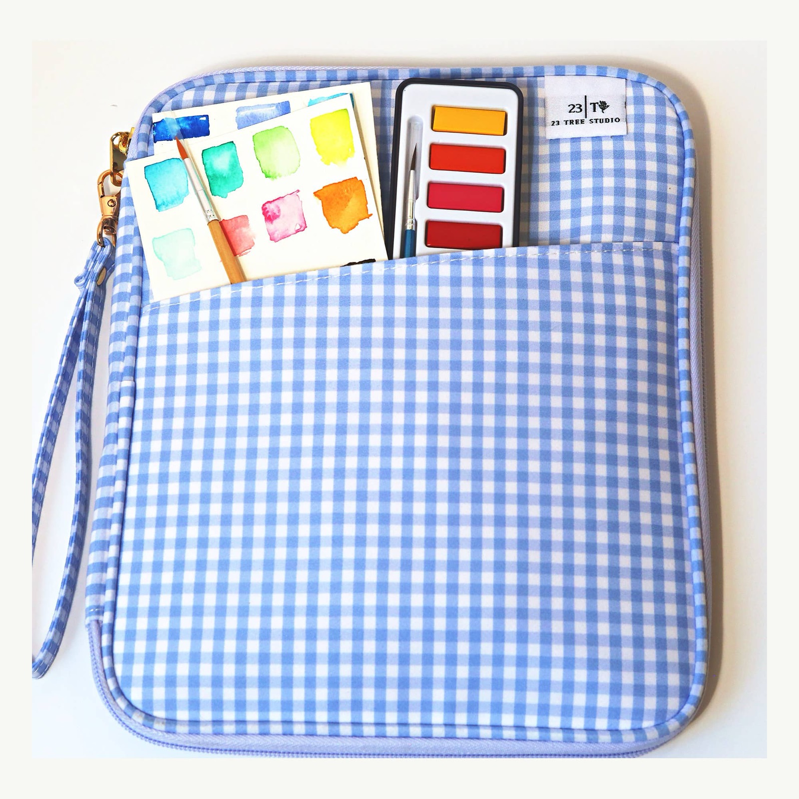 Juliette Watercolor Clutch front pocket styled with swatch cards, brush, and paint set