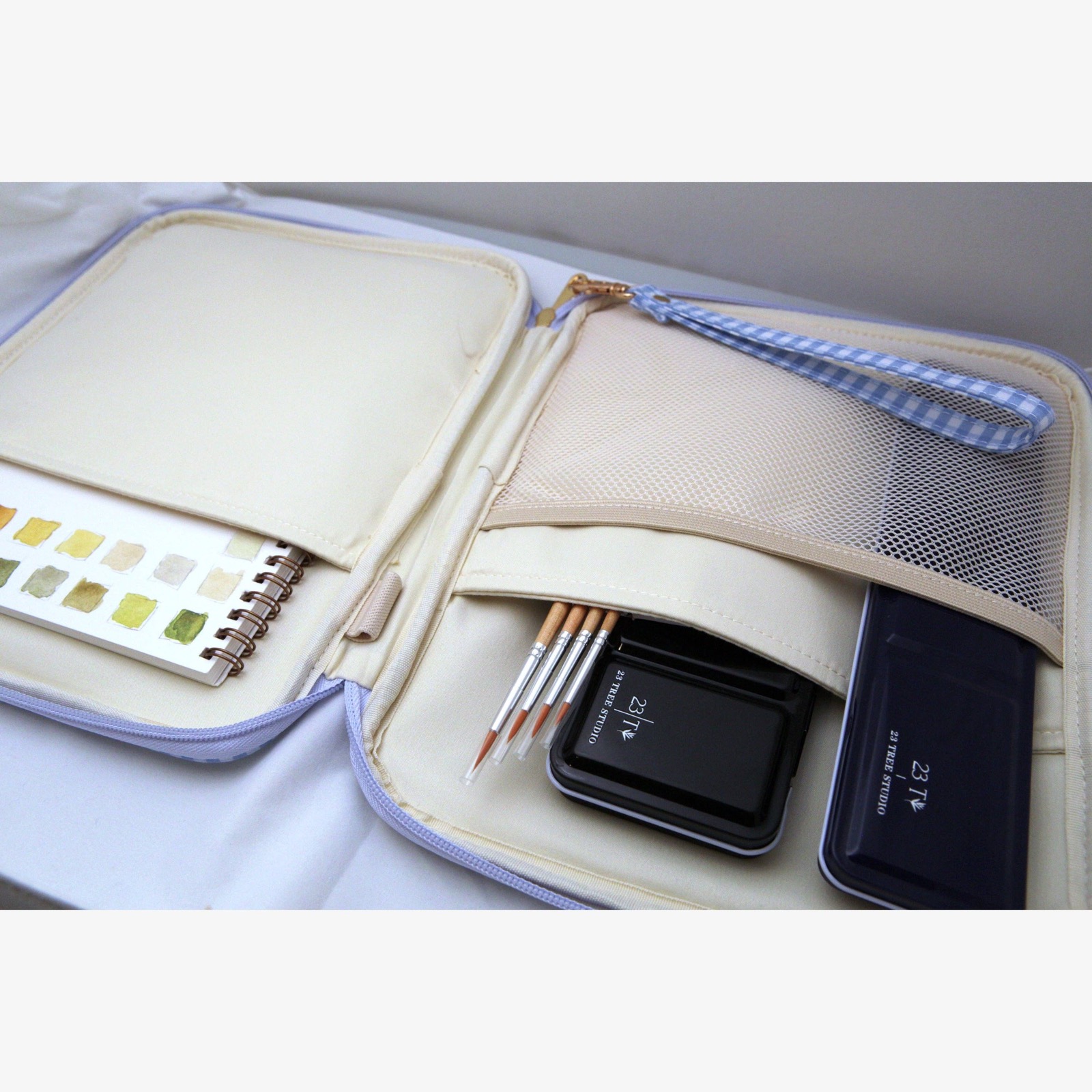 Juliette Watercolor Clutch interior organized with brushes, paint tins, and a swatch book