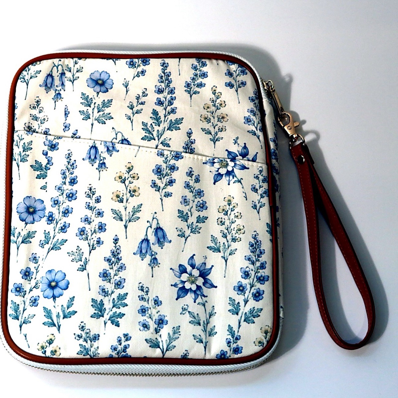 Wildflower-print watercolor clutch with leather trim and wristlet strap